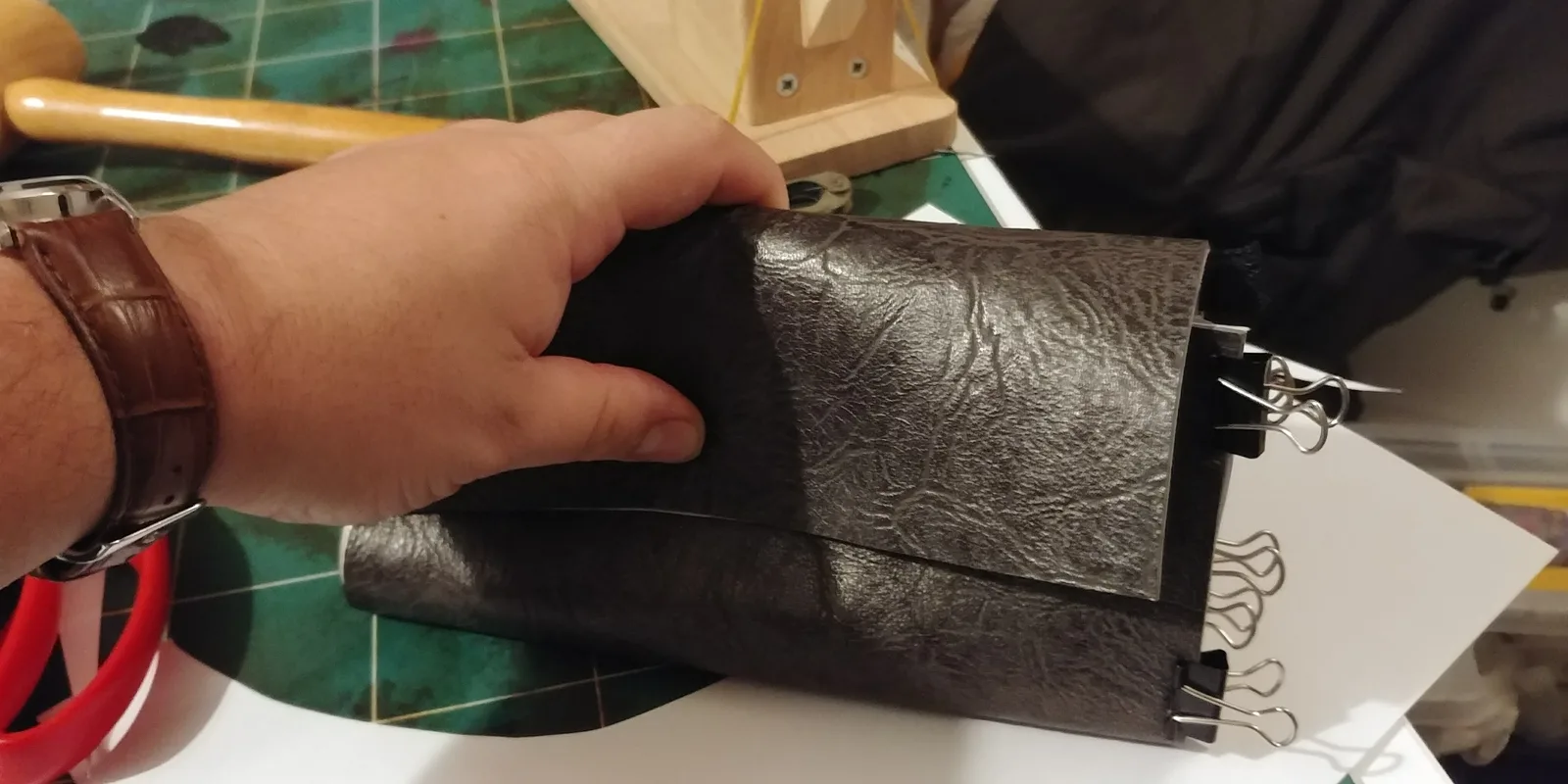 Mains de l'artisan au travail — assemblage d'un portefeuille
